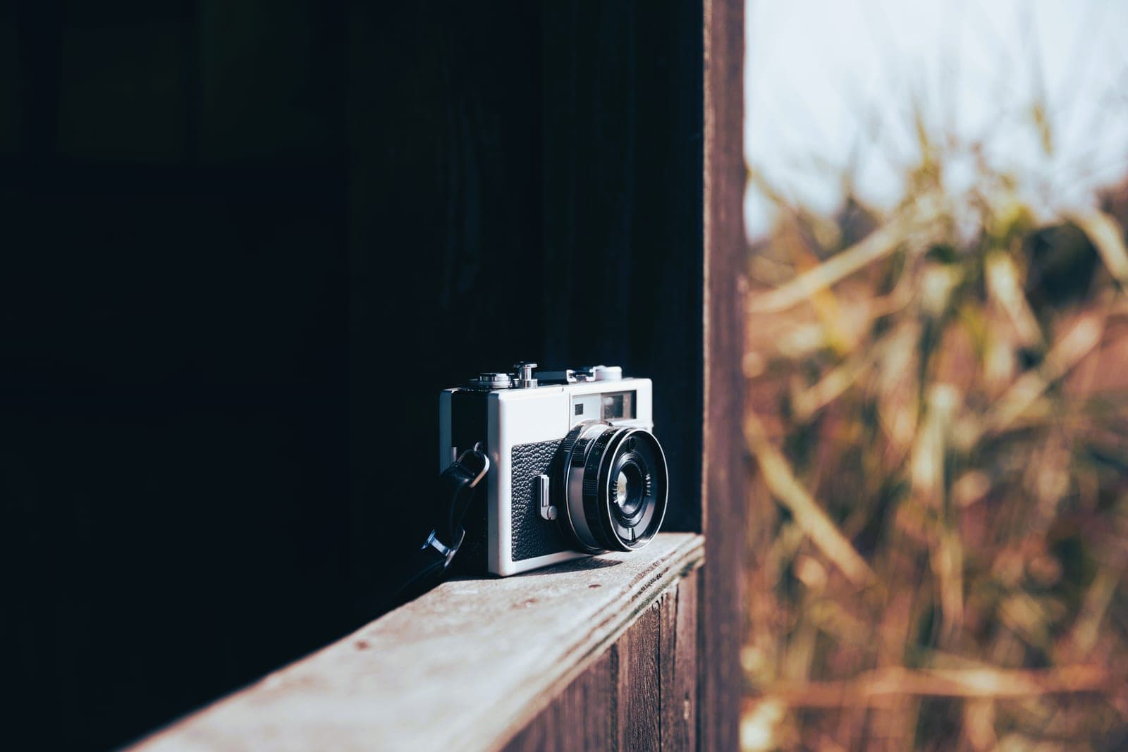 Appareil photo argentique posé sur un rebord en bois